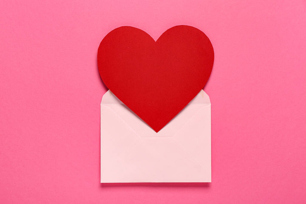 Композиція з конвертом і червоним серцем на рожевому тлі. Святкування Дня святого Валентина - Фото, зображення
