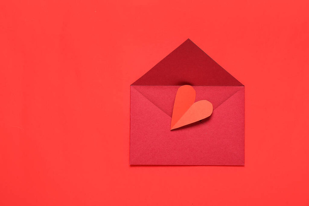 Composición con sobre y corazón de papel sobre fondo rojo. Celebración de San Valentín - Foto, Imagen