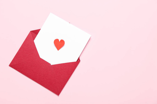 Composición con sobre, tarjeta y corazón de papel sobre fondo rosa. Celebración de San Valentín - Foto, imagen