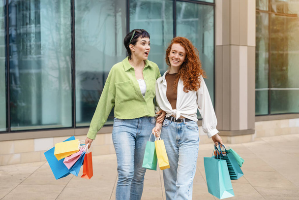 жінки з різнокольоровими сумками весело проводять час з покупками в міському місті. Споживацтво, продаж, покупки, покупки, концепція способу життя. - Фото, зображення
