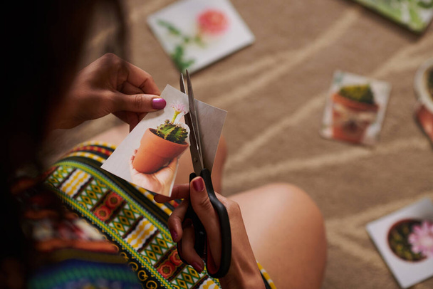 Zbliżenie obrazu kobiety wycinającej obraz kaktusa podczas tworzenia mapy życzeń - Zdjęcie, obraz