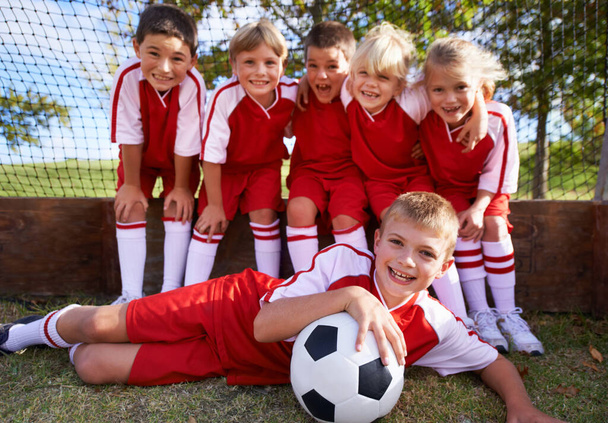 Παιδιά, ποδοσφαιρική ομάδα και πορτρέτο με μπάλα, αγόρια και κορίτσια με παίκτες, υποστήριξη ή αλληλεγγύη. Ενέργεια, αθλητισμός και φιλία, μαζί και χαρούμενοι για τη νίκη, έτοιμοι για παιχνίδι ή σωματική δραστηριότητα. - Φωτογραφία, εικόνα