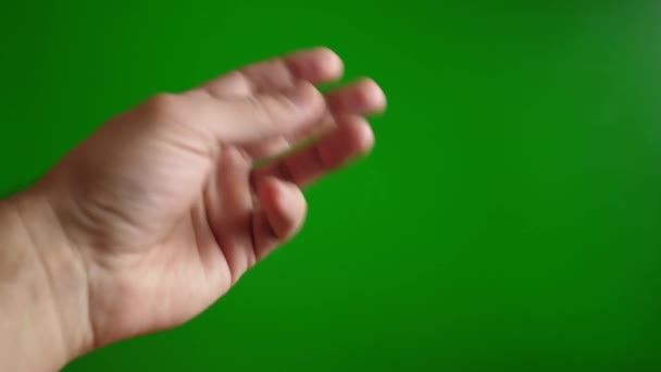 Un uomo mostra un gesto di quello che vuoi con la mano su sfondo verde - Filmati, video