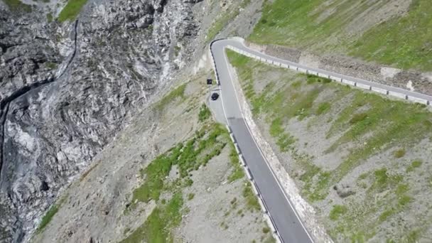 Stilfs, Italy - July 30, 2023: Flight over parked blue Porsche 911 convertible at Stelvio Pass road. The car is a sports car manufactured by Porsche. - Footage, Video