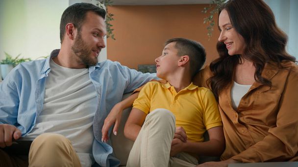Happy Caucasian family relaxing together at home on weekend loving parents mom dad communicate talking with son kid boy child hugging on cozy couch affection love relationship parenthood childcare - Photo, Image