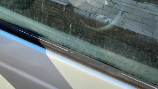 Boczna część porzuconego samochodu, poduszka powietrzna przez brudne okno - Materiał filmowy, wideo