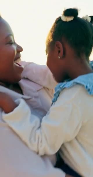 Sunset, dancing and mother with child on beach for summer vacation, weekend trip or holiday. Happy, smile and African mom moving and carrying girl kid by ocean or sea bonding, playing and having fun - Footage, Video