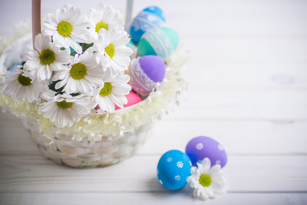 cesta de regalo de Pascua con flores blancas y huevos de colores sobre fondo de madera inspiración primavera
 - Foto, imagen