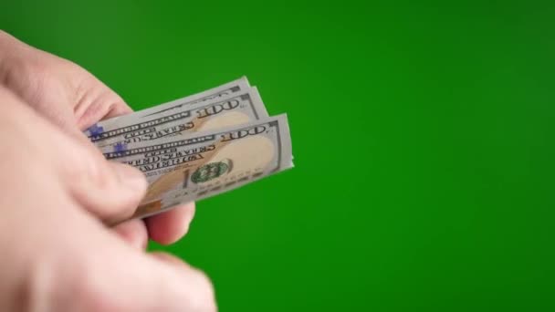 Un hombre cuenta dólares con un fondo verde - Imágenes, Vídeo
