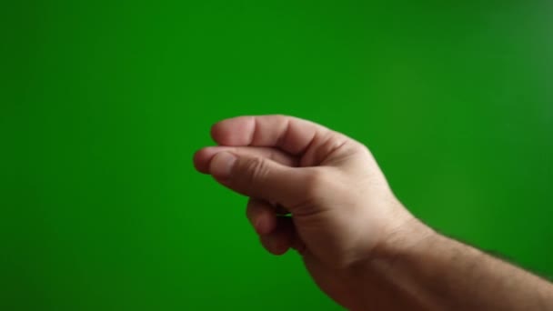 Haciendo clic en los dedos de una mano masculina sobre un fondo verde. El concepto de facilidad y simplicidad. Movimiento lento. - Imágenes, Vídeo