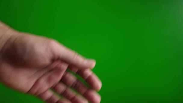Ein Mann zeigt eine "so-so" -Geste mit der Hand auf grünem Hintergrund. Zeitlupe - Filmmaterial, Video
