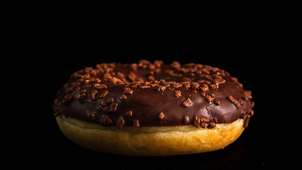 Chocolade geglazuurde donut met chocolade chips geïsoleerd. Close-up van heerlijke donut. - Foto, afbeelding