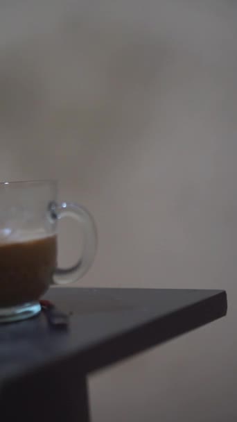 όμορφο κάθετο βίντεο πορτρέτο ενός φλιτζανιού καφέ γάλακτος σε λευκό ποτήρι, σε μαύρο τραπέζι - Πλάνα, βίντεο