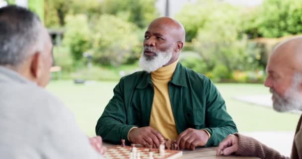 Muž, šachy a hra s mluvit o strategii tím, že plánuje vyhrát v parku, zahradě nebo venku. Starší lidé, přátelé a společně pro zábavu, výzvu nebo turnaj pro hru v důchodu se soutěží. - Záběry, video