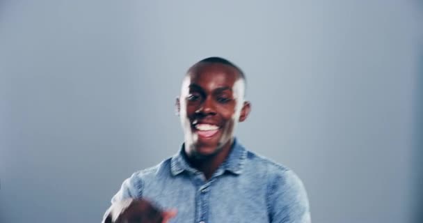 Danser, feest en gezicht van de zwarte man in de studio voor feest, overwinning en opgewonden op grijze achtergrond. Glimlach, energie en portret van geïsoleerde gelukkige persoon die zich verplaatst naar audio-, muziek- en liedafspeellijst. - Video