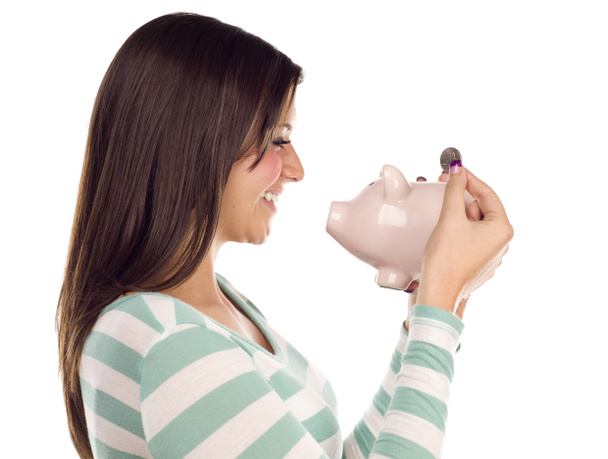Etnia feminina colocando moeda em Piggy Bank em branco
 - Foto, Imagem