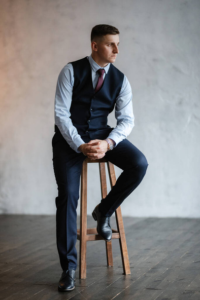 portrait of a cheerful groom in a blue suit in the studio - Photo, Image