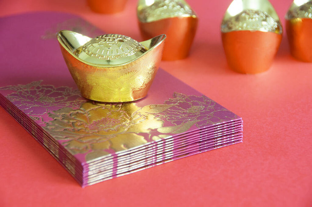 Китайський Новий рік червоні пакети і золотий злиток на жовтій обкладинці. Настроюваний простір для тексту - Фото, зображення