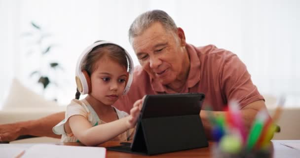 Online-oppiminen, kotitehtävät ja lapsen kanssa isoisä tabletilla koulutukseen, verkko-oppimiseen ja opiskeluun kotona. Koulu, perhe ja nuori tyttö isovanhemman kanssa opetukseen, tietoon ja testiin. - Materiaali, video