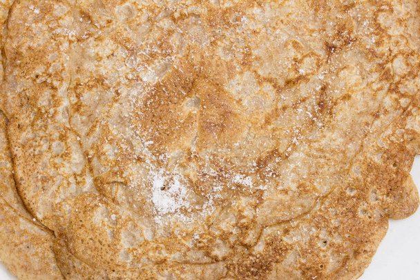 Vista aerea di un primo piano di crepes spagnole condite con dolcificante in polvere. Dolce tradizionale. - Foto, immagini