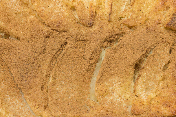 An overhead close-up shot of a freshly baked apple pie, a homemade dessert, dusted with powdered cinnamon creating an irresistible combination.  Healthy dessert options without added sugars. - Photo, Image