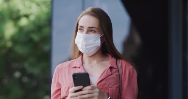 Face mask, city and woman with phone walking for safety, protection and hygiene for pandemic sickness. Healthcare, smartphone and person on commute, travel or journey for wellness in town epidemic. - Footage, Video