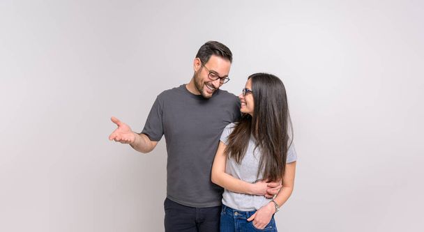 Glücklich romantischer Freund mit Arm um Freundin flirtet mit ihr auf isoliertem weißem Hintergrund - Foto, Bild