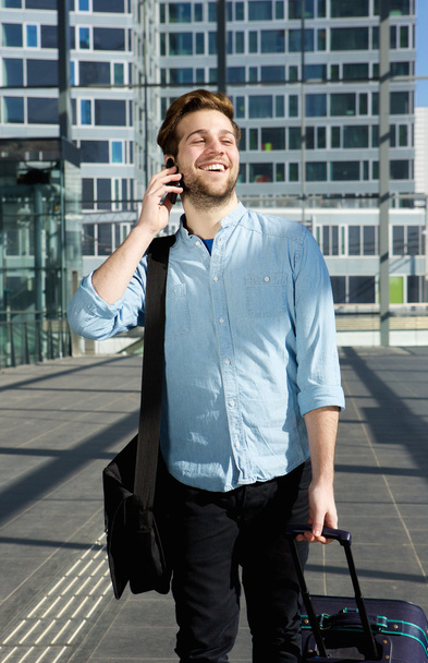 Onnellinen mies kävelee matkapuhelimen kanssa lentokentällä
 - Valokuva, kuva