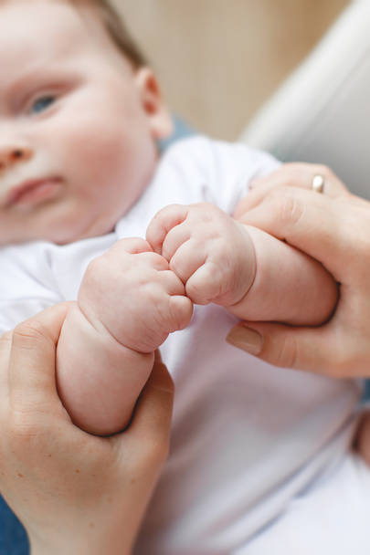 Una madre sostiene tiernamente la mano de un bebé recién nacido
. - Foto, imagen