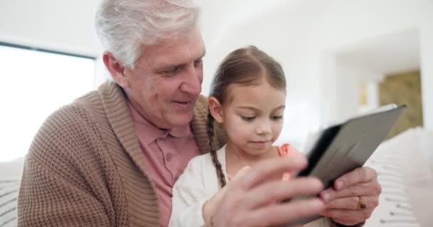 Nagyapa, lány gyermek és tabletta otthoni oktatás, e tanulási támogatás és beszélgetés, olvasás vagy boldog honlap játékok. Család, gyerek és idős férfi tanít digitális technológia iskolai könyv. - Felvétel, videó