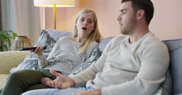 Young siblings, sofa and remote watching TV for movie, series or channel change at home. Brother asking sister for control for gaming entertainment, time or taking turns together in living at house. - Footage, Video