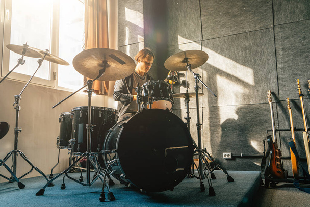 Retrato do baterista sentado no kit de bateria em estúdio de gravação de som no ensaio da banda de música. - Foto, Imagem