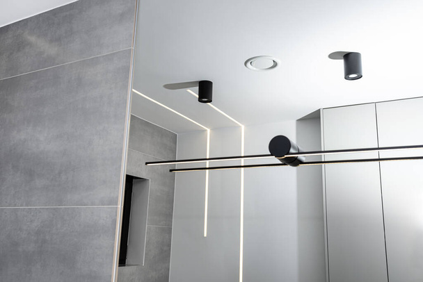 Светодиодные светодиодные полоски, установленные в стене и потолке в современной ванной комнате, видимый вентиляционный анемостат. - Фото, изображение
