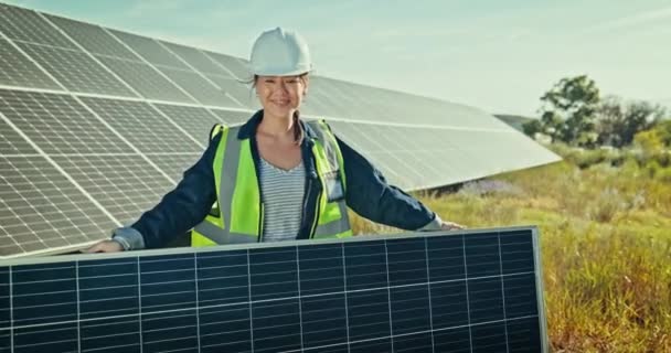 Asian engineer woman, solar panel and outdoor with smile on face for renewable energy, ecology and sustainability. Photovoltaic technician, field and happy in portrait at construction site for grid. - Footage, Video
