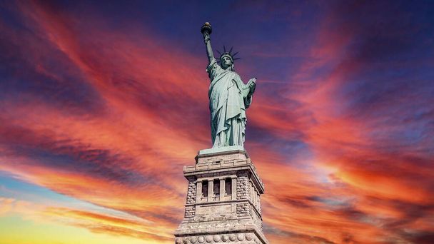 The Lady of New York (USA), je slavná socha svobody Velkého jablka a Manhattanu, známá po celém světě, pod načervenalým nebem za úsvitu. - Fotografie, Obrázek