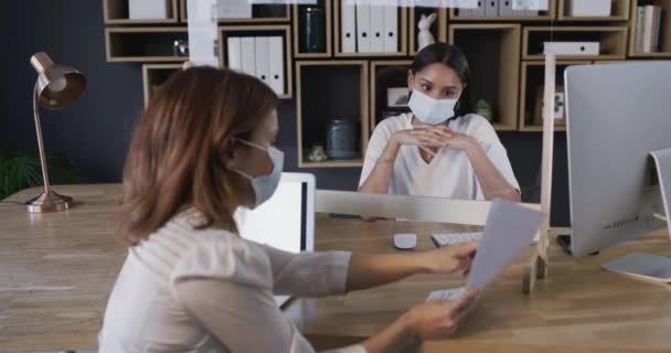 Colleagues, business meeting and masks with documents, covid and talking, financial plan and workers. Pandemic, woman and tech with internet, working or project for financing, workplace and safety. - Footage, Video
