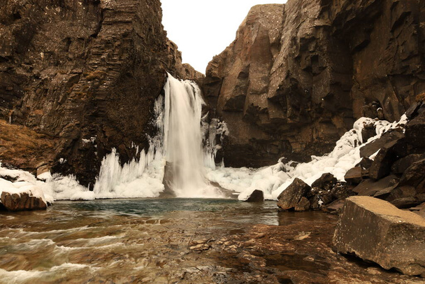 Nykurhylsfoss был своего рода скрытый, неизведанный водопад в Fossardalur на реке Фосса, когда он свернул и упал на Беруфьорд в Исландии Eastfjords - Фото, изображение