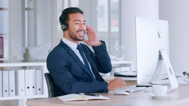 Zelfverzekerde mannelijke call center agent praten op de headset en kijken ontspannen tijdens het werken in een kantoor. Succesvolle en grappige verkoper consulting en het bedienen van een helpdesk voor klantenservice en ondersteuning. - Video