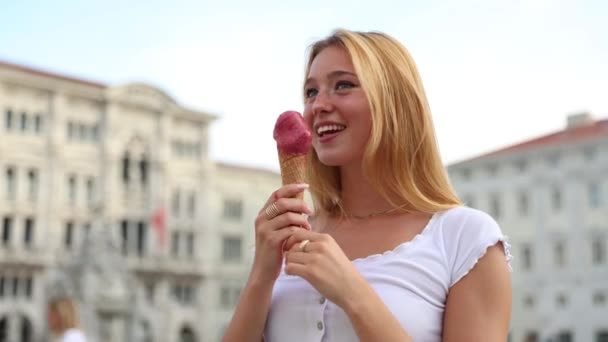 Una chica come helado en el centro de la ciudad durante el verano y es feliz - Metraje, vídeo