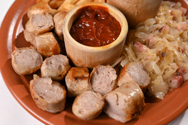 plate for food French fries sausage white sausage and sauerkraut herb sauce and ketchup typical German food taste - Photo, Image