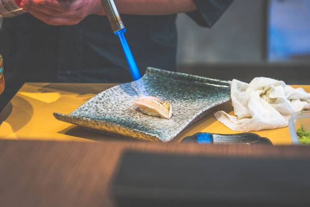 chef's hands making japanese rice sushi in a japanese restaurant - Photo, Image