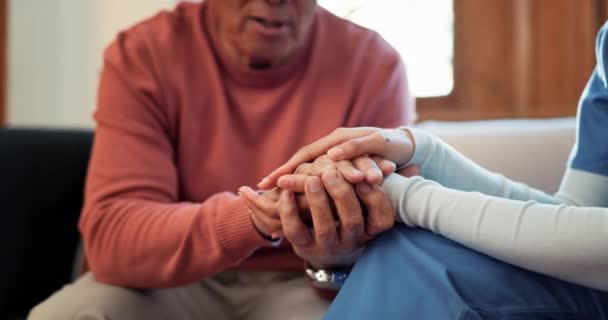 Nurse, holding hands and care in support, trust or healthcare for understanding on living room sofa at home. Closeup of people touching in grief, loss or kindness for nursing or elderly care at house. - Footage, Video
