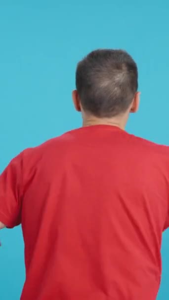 Video ve studiu s barevným zadním pohledem na muže mávajícího kanadskou vlajkou - Záběry, video