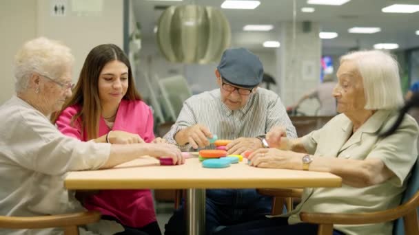 Video che si avvicina a un infermiere e residenti di una casa di cura risolvere i giochi di abilità cervello - Filmati, video