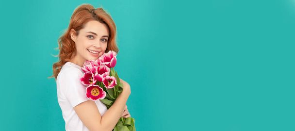 glad girl with tulip flower bouquet on blue background. Woman isolated face portrait, banner with mock up copyspace - Photo, Image