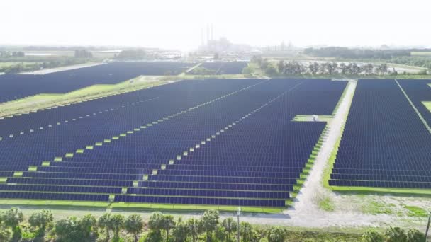 Ilmakuva suuresta kestävästä sähkövoimalasta, jossa on monia rivejä aurinkosähköpaneeleita puhtaan sähköenergian tuottamiseksi. Päästöttömän uusiutuvan sähkön käsite. - Materiaali, video