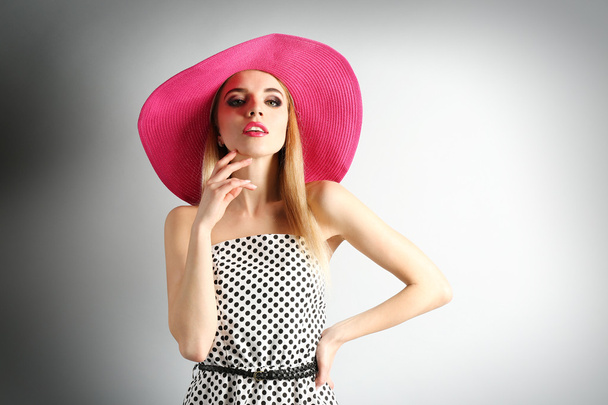 Expressive young model in pink hat on gray background - Foto, imagen