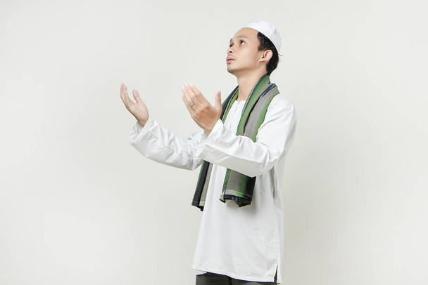 szczęśliwy azjatycki muzułmanin modlący się gestem ręki, trzymający dłoń w górze. Ludzie religijny islam koncepcja stylu życia. świętowanie Ramadan i ied Mubarak. na odizolowanym tle - Zdjęcie, obraz