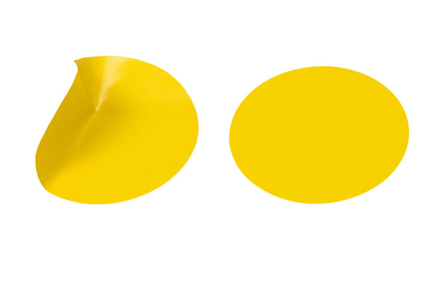 Runde gelbe Aufkleber, leere Etiketten auf weißem Hintergrund. Ansicht von oben.  - Foto, Bild