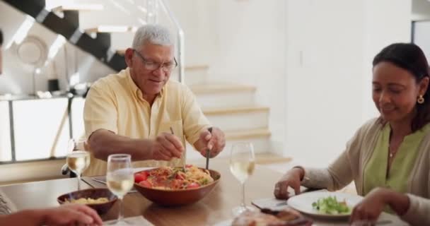 Familie, diner en gelukkig in de eetkamer met voedsel voor hechting, evenement of gesprek in de lounge gebied van thuis. Liefde, grootouders of ouders met kinderen voor pasta, avondeten of brunch met geluk. - Video